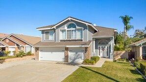 A two-story house with a garage, a well-maintained lawn, and a clear blue sky. - 6 bedroom Large house. Near Airport,Outlets Mall, No Party, Pets Friendly (Ontario)
