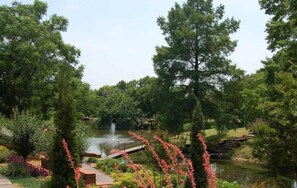 A serene park with a pond, a bridge, and lush greenery. - Harmony Studio 5min-asian Dist Full Kitchen (Oklahoma City)