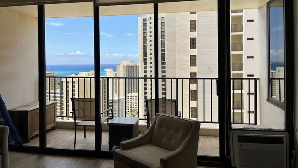 A balcony with a view of the ocean and high-rise buildings.