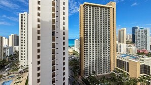 Un immeuble de grande hauteur au design moderne, caractérisé par une structure verticale imposante et une série de balcons.