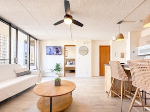 Ein modernes Wohnzimmer mit einer Couch, einem runden Couchtisch und Korbstühlen.