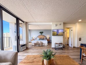 Une chambre spacieuse avec un grand lit, des tables de chevet, une télévision et une vue sur l’extérieur.