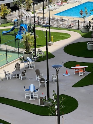 Ein Poolbereich mit Liegestühlen, einer Rutsche und einem Spielbereich für Kinder.