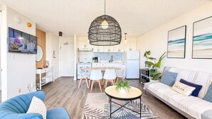 Ein modernes Wohnzimmer mit Sofa, Couchtisch und Essbereich mit Stühlen.