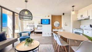 Eine moderne Küche mit Essbereich, einer Couch und einem Fernseher.