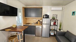 Enjoy cooking in this well-equipped kitchen with a central island, sink, and microwave, adjacent to a comfortable living area.