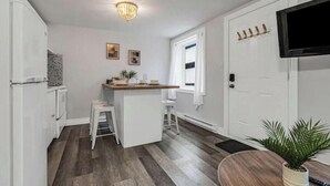 A compact kitchen with a central island, white cabinetry, and a modern chandelier.