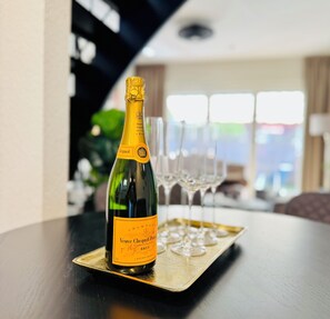Une bouteille de champagne Veuve Clicquot sur un plateau, accompagnée de deux verres.