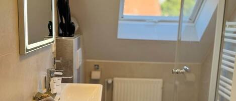 Ein Badezimmer mit Waschbecken, Toilette und einem Fenster.