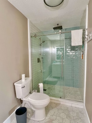 A bathroom with a glass-enclosed shower, a toilet, and a bidet. - Steps to the Sand – 2BR Melbourne Beach Townhome (Melbourne Beach)