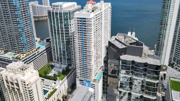 A high-rise hotel with multiple floors, balconies, and a pool area. - Superb Private unit Perfectly Located In Brickell (Miami)