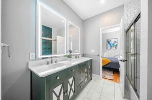 A modern bathroom with dual sinks, a large mirror, and a walk-in shower. - Experience Atlanta in Comfort: 4-Bedroom Home with WiFi, AC & More (Atlanta)