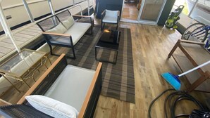 L'intérieur d'un bateau, avec un canapé, des fauteuils, une table et une fenêtre donnant sur l'eau.