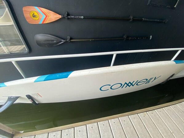 A boat with the name 'CONWAY' on its side, a paddle, and a life preserver.