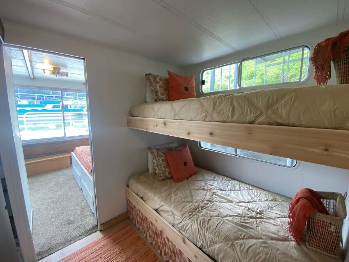 Una cama litera con dos niveles, una ventana y una puerta que da a un área exterior.