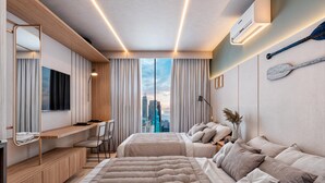 Ein modernes Hotelzimmer mit einem großen Bett, einem Schreibtisch und Blick auf die Stadt.