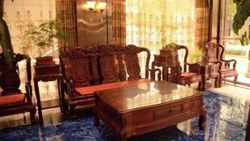 A room with a wooden coffee table, matching chairs, and a patterned floor.