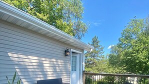 A deck with a sofa, two chairs, and a coffee table. - Charming 3-bedroom house with WiFi, AC in serene Noblesville (Noblesville)