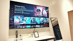 Una TV a schermo piatto fissata a una parete mostra un menu con diverse opzioni di film.
