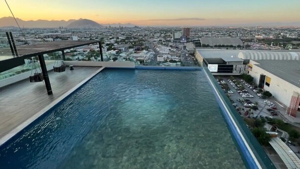 A rooftop pool with a clear view of the cityscape and mountains in the background. - Departamento Punta Cero, Cintermex (Monterrey)