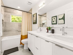 A modern bathroom with a bathtub, toilet, and a large mirror. - Downtown Austin Luxury Stay ★ Hot Tub • Fire Pit • Minigolf (Austin)