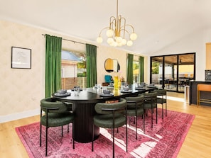 A dining area with a round table, chairs, a chandelier, and a view of the outside. - Downtown Austin Luxury Stay ★ Hot Tub • Fire Pit • Minigolf (Austin)