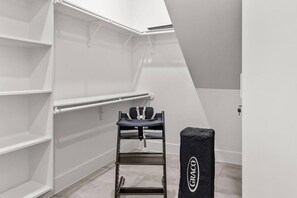 A storage closet with shelves, a chair, and a Graco storage bag. - Downtown Austin Luxury Stay ★ Hot Tub • Fire Pit • Minigolf (Austin)