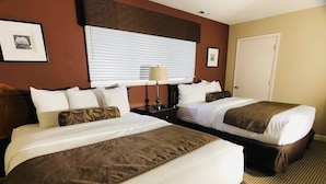 A hotel room with two beds, a large window with blinds, a bedside lamp, and a door. - Awesome Condo in Acme, Michigan (Williamsburg)