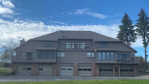 A two-story building with a flat roof, large windows, and a garage. - Awesome Condo in Acme, Michigan (Williamsburg)