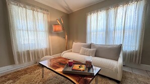 Een woonkamer met een bank, een salontafel met dienblad en een lamp.
