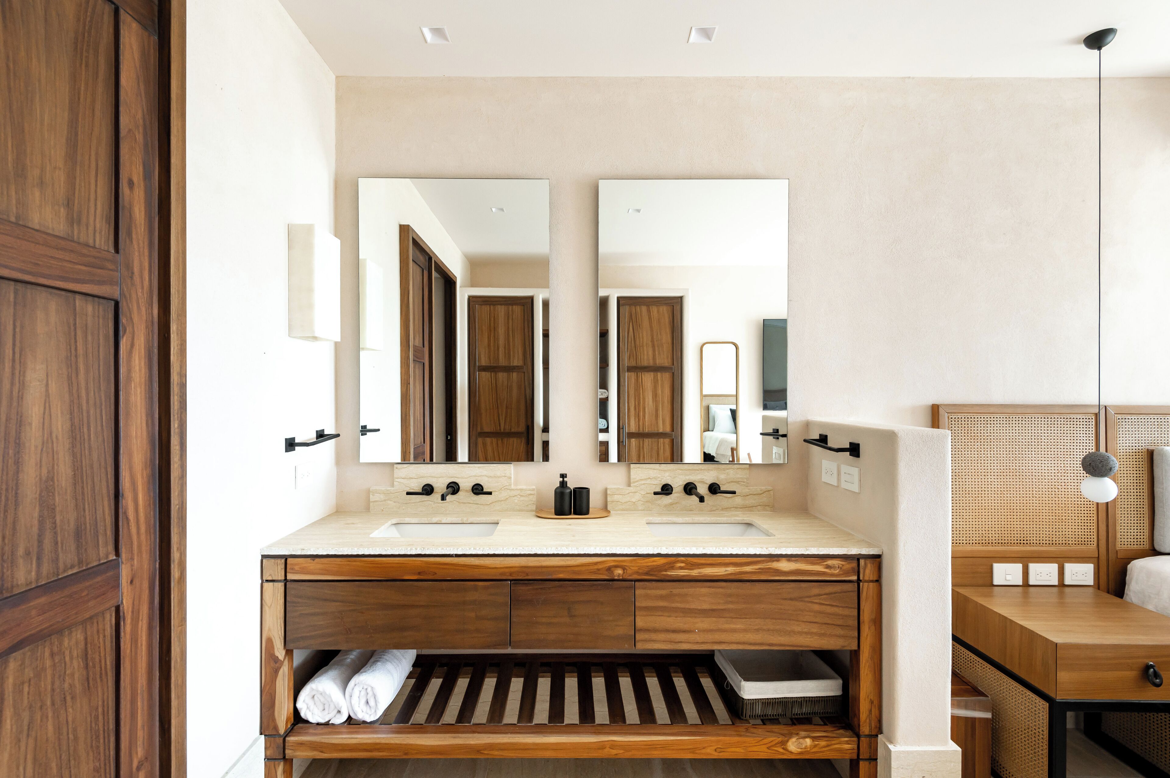 Une salle de bain moderne avec un meuble-lavabo en bois, deux vasques et un grand miroir.