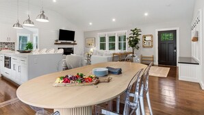 A modern kitchen with a central island, pendant lighting, and a dining area with a long table. - Upscale Secluded Home w/Central AC, Pool & Firepit (Centerville,)