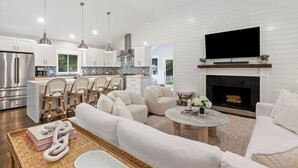 A modern kitchen with white cabinets, stainless steel appliances, and hanging pendant lights. - Upscale Secluded Home w/Central AC, Pool & Firepit (Centerville,)