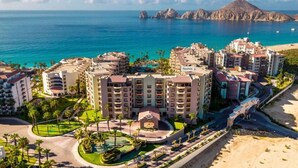 Un hôtel situé sur la côte, composé de plusieurs bâtiments, doté d’une piscine et offrant une vue sur la plage.