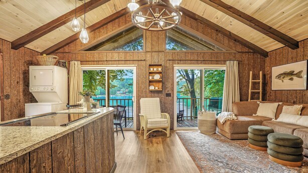 A rustic cabin interior with a kitchen, dining area, and living room. - Charming Cabin on Lake Malone – Perfect Getaway! ~Lakefront w/ firepit~ (Lewisburg)