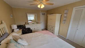 Un dormitorio con cama, cómoda, tocador y armario.