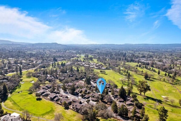 Vista aérea de una zona residencial con casas, áreas verdes y un campo de golf.