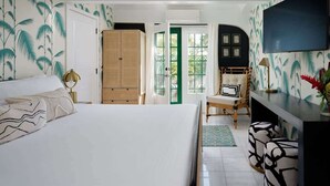 Ein Schlafzimmer mit Bett, Schreibtisch, Stuhl, Kleiderschrank und Fernseher.