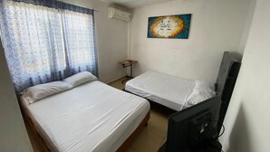 A room with two beds, a television, and a painting on the wall. - Santa Rosa 4Rest (Apodaca)