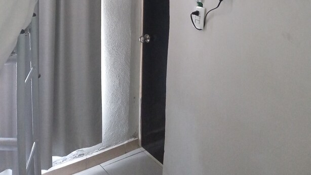 A bathroom with a white sink, a mirror, and a black television mounted on the wall. - Santa Rosa 4Rest (Apodaca)