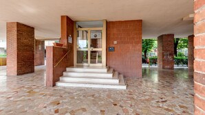 A spacious lobby with a terrazzo floor, a staircase, and brick walls. - Boho - Sweet Dreams in Florence (Firenze)