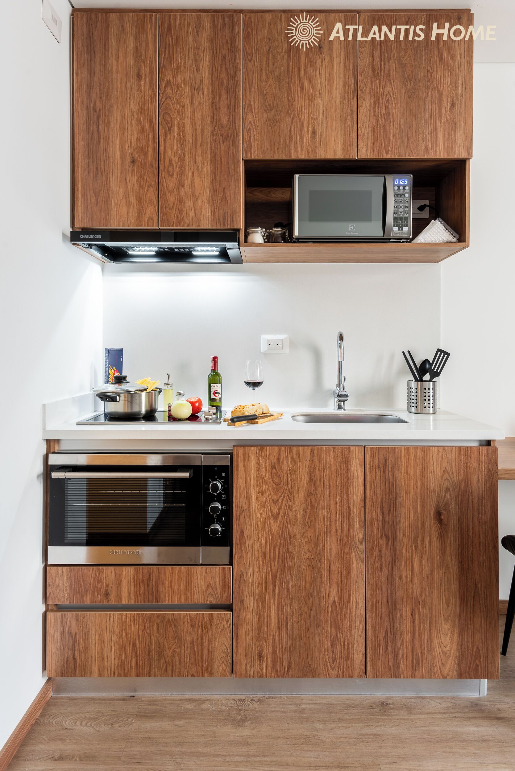 A modern kitchen with wooden cabinets, a built-in microwave, a stainless steel oven, and a sink with a knife block.