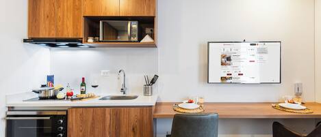A modern kitchen with wooden cabinets, a built-in oven, and a digital display.