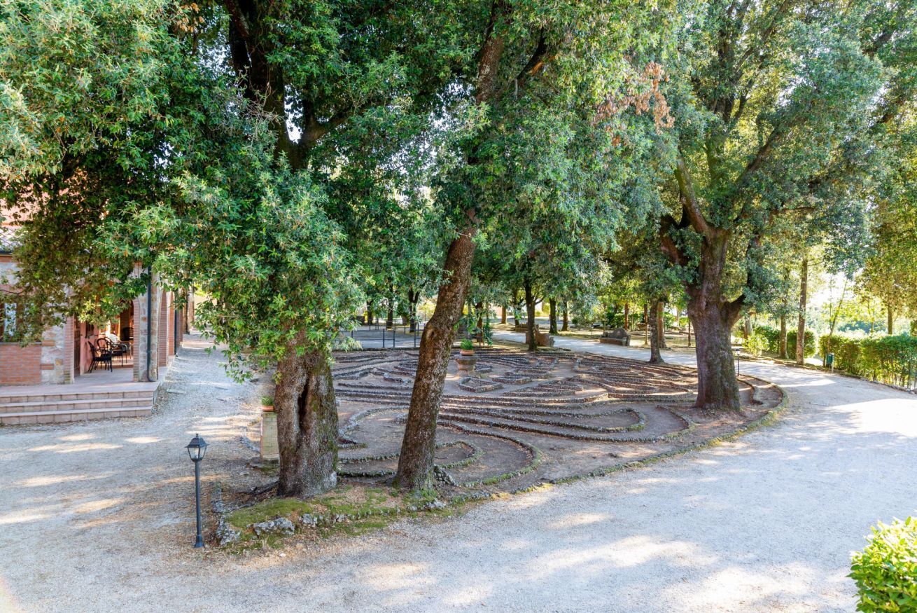Un jardín laberinto con árboles y un sendero.