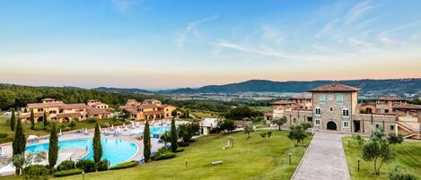 A resort with a swimming pool, a central building, and surrounding villas.