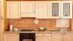 Uma cozinha com armários de madeira, fogão, forno e pia.