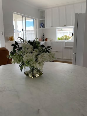 Enjoy a kitchen with a large window offering a view of the outdoors, a kitchen island, and a refrigerator.