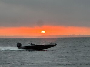 Un bateau naviguant sur une étendue d’eau au coucher du soleil.