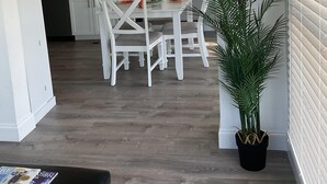 A modern kitchen with white cabinets, a dining area with white chairs, and a potted plant. - Bimini Breeze - VO 313 (Cudjoe key)