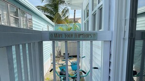 A porch with a sign that reads "Wipe Your Flip Flops". - Bimini Breeze - VO 313 (Cudjoe key)